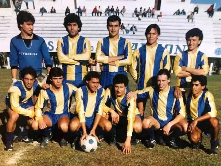 Plantel histórico de Juveniles del Campito posando con la camiseta tradicional a bastones frente a la tribuna.