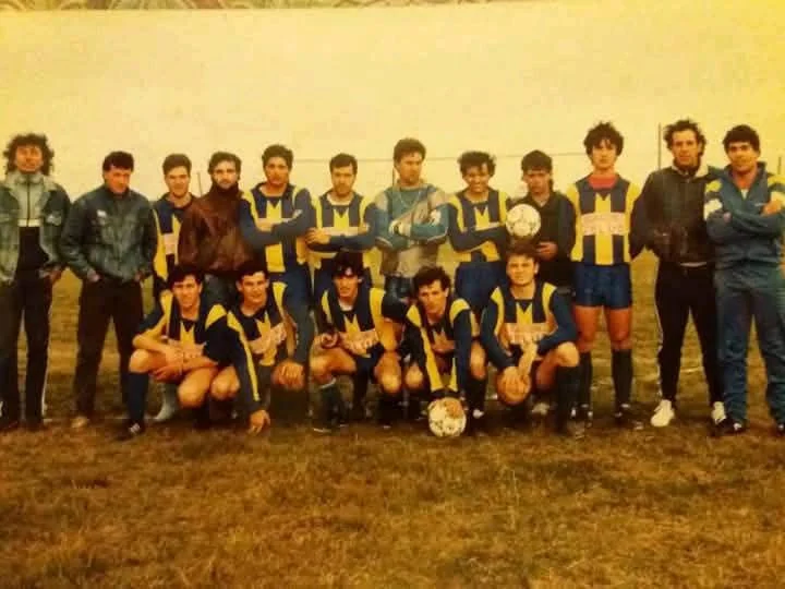 Plantel histórico de Juveniles del Campito en formación con camisetas a bastones en el campo de juego.